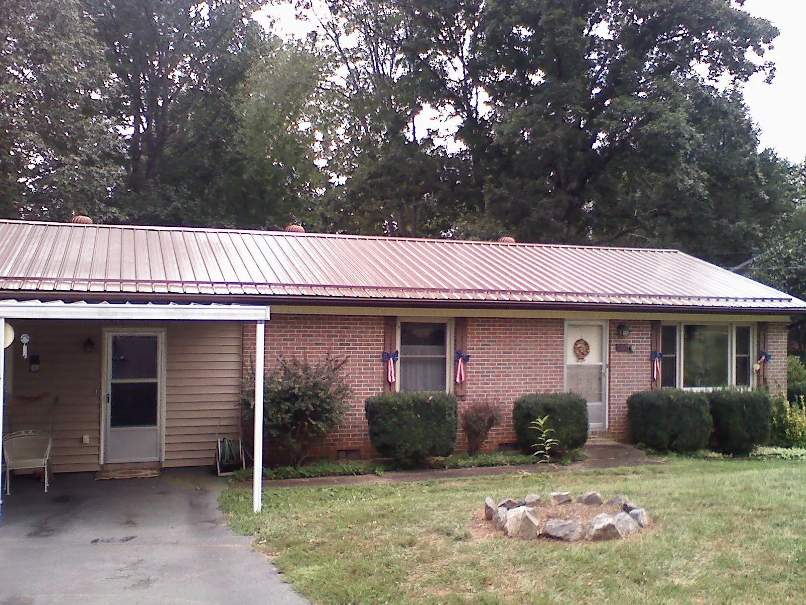 Bronze metal roof and carport on a brick ranch home — Roof Repair work by our crew in Wellsburg